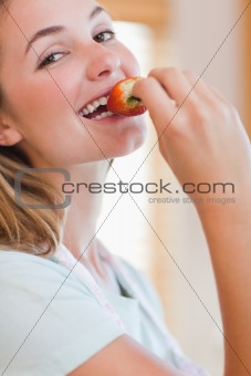 Close up of a young woman eating a strawberry