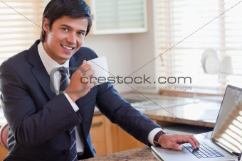 Man working with a notebook while drinking coffee