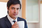 Close up of a handsome businessman drinking coffee