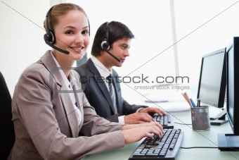 Smiling office workers using computers