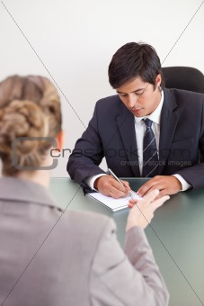 Portrait of a handsome manager interviewing a female applicant
