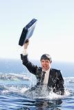 Portrait of a young businessman going out of the water with a briefcase