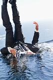 Portrait of a cheerful businessman falling into water