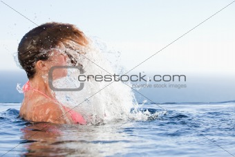 Young woman raising her head out of the water