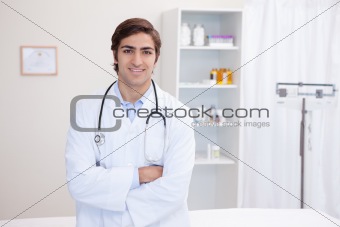 Male doctor standing with arms folded