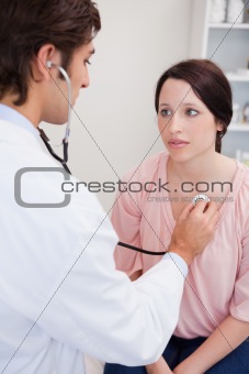 Doctor taking his patients heart beat