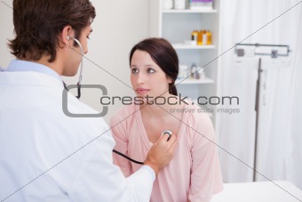 Young doctor taking his patients heart beat