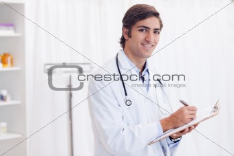 Side view of smiling doctor taking notes
