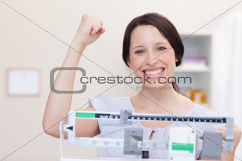 Young woman happy about what the scale shows