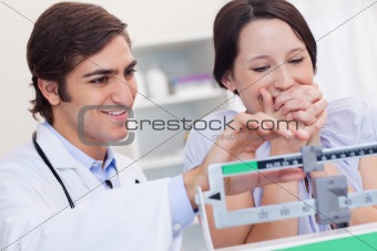 Doctor adjusting scale for excited patient
