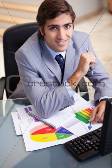 Smiling businessman working on statistics