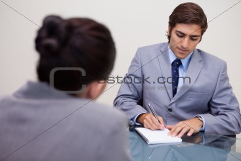 Businessman in meeting taking notes
