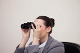 Businesswoman having a look through binoculars