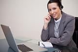 Smiling businesswoman with headset on her laptop