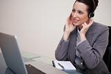 Businesswoman with headset sitting at her desk