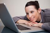 Smiling businesswoman leaning against her laptop