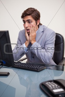 Businessman getting negative surprised by his computer