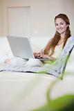 Young woman sitting on the sofa with her laptop