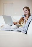Woman on the sofa booking a flight online