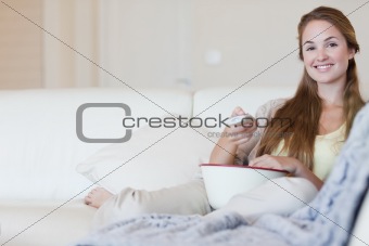 Woman with a bowl of popcorn watching a movie