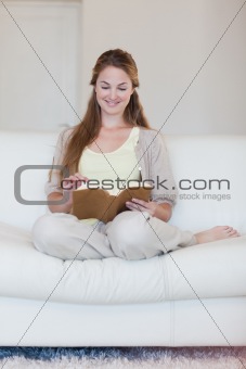 Woman enjoys reading a book on her sofa