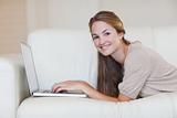 Side view of woman lying on the sofa surfing the internet