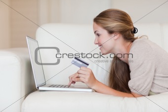 Side view of woman on the sofa shopping online