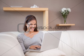 Smiling woman with her notebook on the sofa