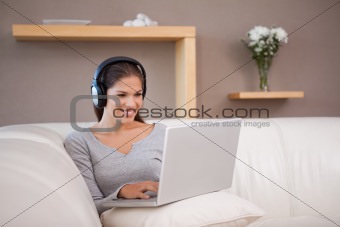 Woman enjoys listening to music on her laptop