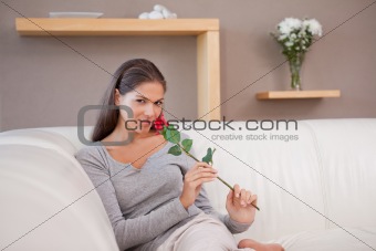 Woman with a red rose sitting on the sofa