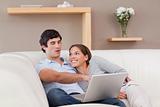 Couple with their laptop on the sofa