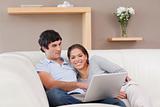 Couple with their laptop on the couch