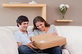 Couple on the sofa opening parcel