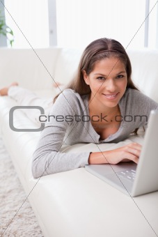 Woman on the sofa typing on her laptop