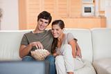 Couple with popcorn on the sofa watching a movie