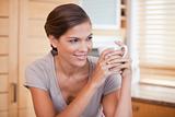 Smiling woman enjoying a cup of coffee