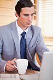 Businessman with coffee on his laptop