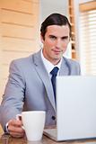 Businessman with laptop and tea