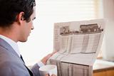 Side view of businessman reading newspaper