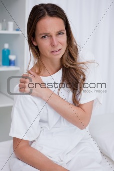 Woman covering painful shoulder