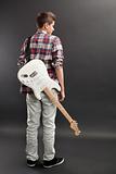 Teenager standing with electric guitar