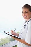 Side view of smiling doctor with clipboard