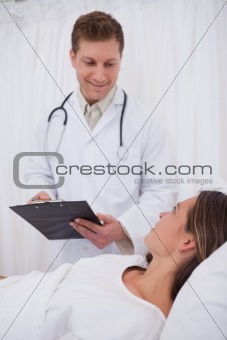 Doctor talking with bedridden patient