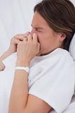 Side view of women in bed sneezing