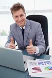 Happy businessman giving thumbs up
