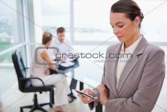 Standing real estate agent with cellphone