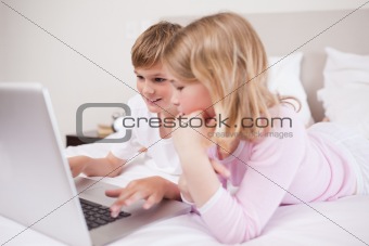 Smiling children using a laptop