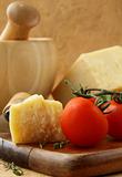 Cheese parmesan on a wooden board with tomatoes