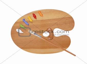 wooden art palette with blobs of paint and a brush on white back