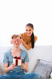 Young woman cover eyes to waiting present boyfriend
